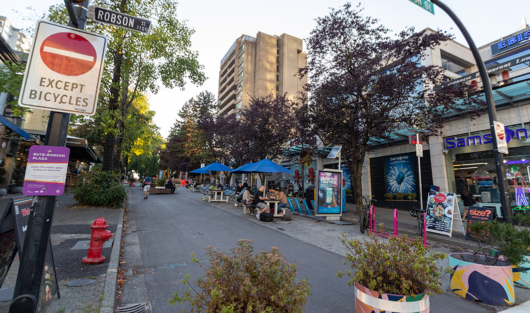 Bute-Robson Plaza on Bute St featuring a car-free street with picnic tables with blue garden umbrellas 