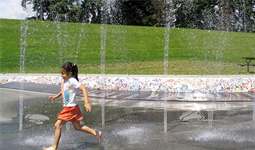 Child running through spray park
