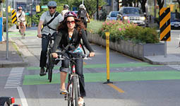 Cyclists biking uphill on a protected bike lane. 