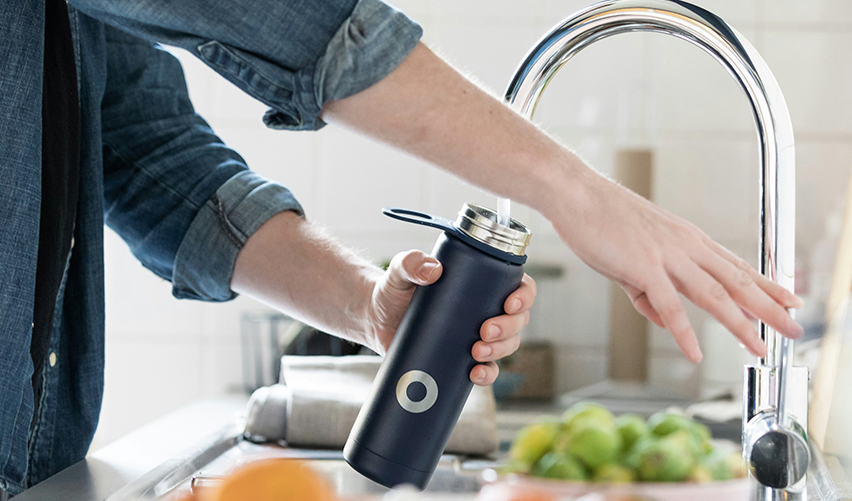 Person filling up water bottle from the tap