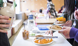 Food on a table with people gathered around