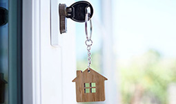 Key in a door lock with a house-shaped keychain
