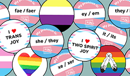 Pronoun and pride buttons with various identities and LGBTQ flags.