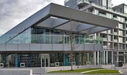 Exterior of a modern building with large windows and a covered terrace.