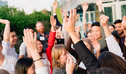 Group of people raising their hands while outdoors