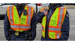 Two people wearing high-visibility vests