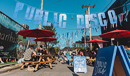 Small block gathering on the street with picnic tables