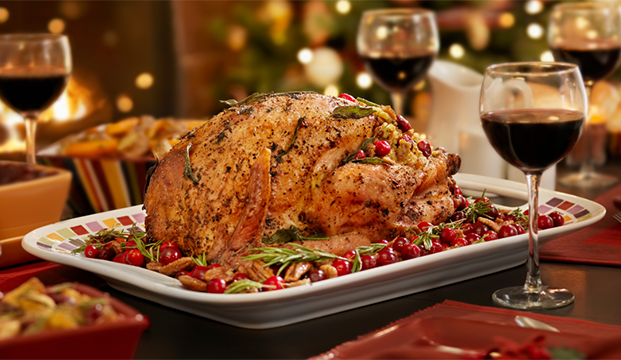 A roast turkey with wine glasses on a table