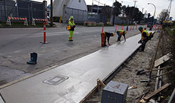 Group of 4 City workers finishing off a new sidewalk