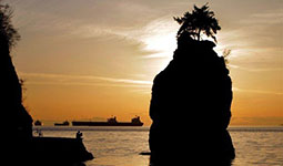 Tall sea stack offshore at sunset near Stanley Park