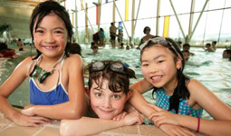 Kids leaning on the edge of a pool