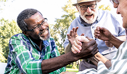 Three seniors laughing and holding hands