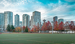 Urban park with a synthetic sports field in the foreground and downtown Vancouver skyline in the background