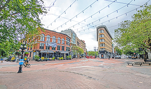 A view of Water Street in Gastown featuring cobblestone roads and Hotel Europe. 