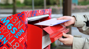 A person drops their mail into a Canada Post box